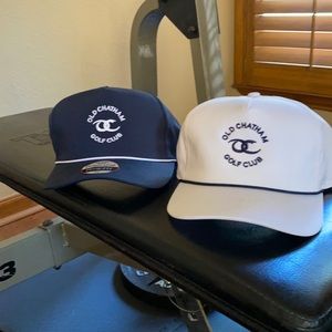 Two hats, one white with black lettering and one navy with white lettering.